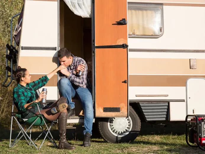 Ung mand og kvinde foran campingvogn